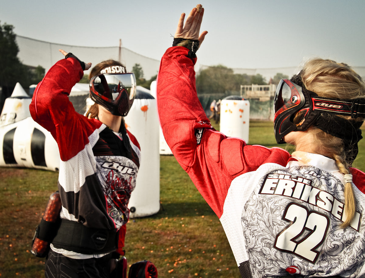 Zwei Paintball-Spieler geben sich die Hand auf einem Paintball-Feld 